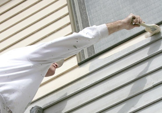 Man repainting old vinyl siding